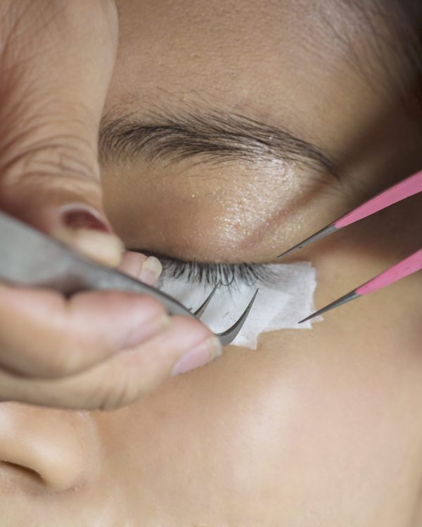Young woman getting artificial lash treatment in a beauty salon